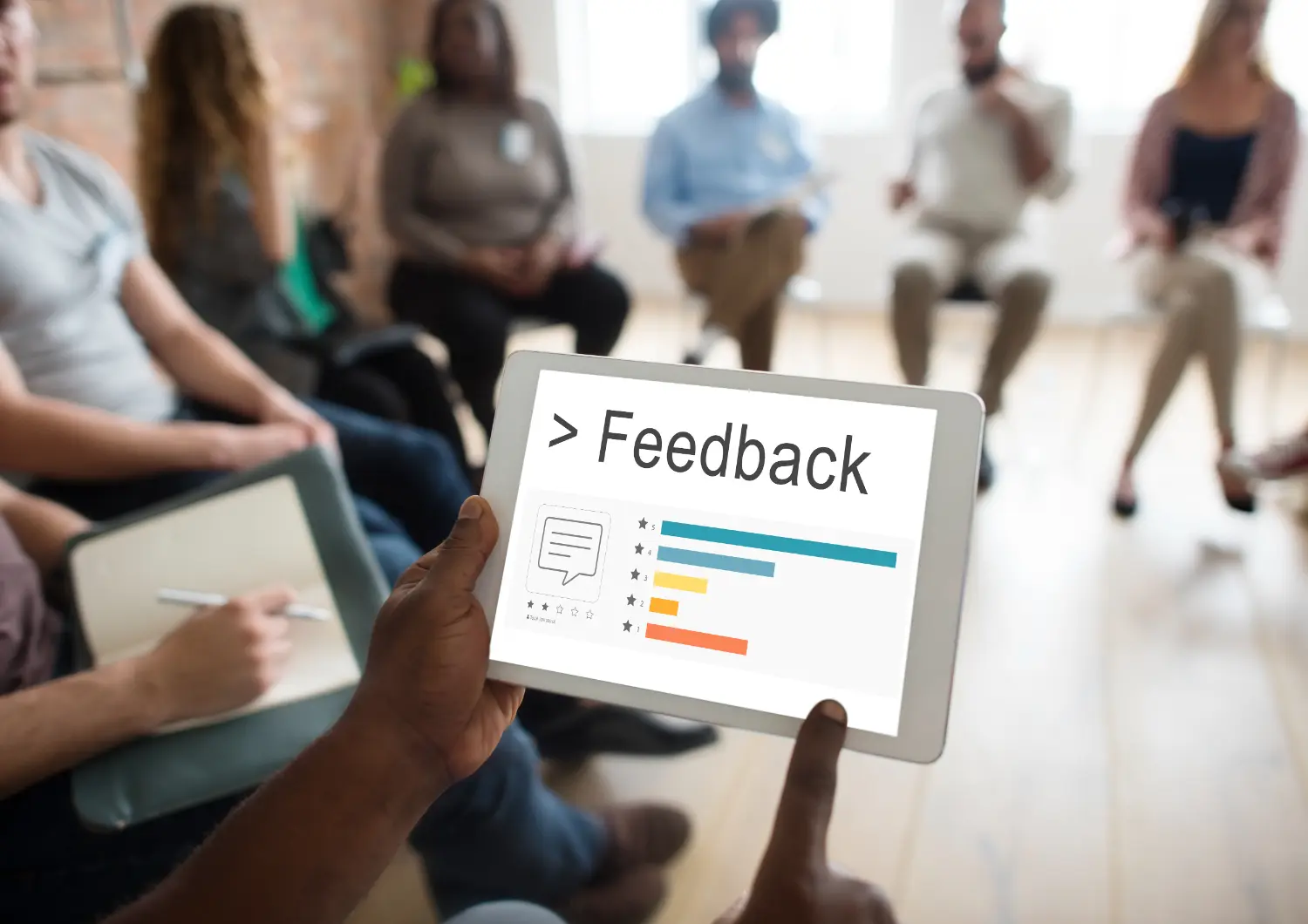 pessoa em ambiente de trabalho dando feedback para demais colaboradores